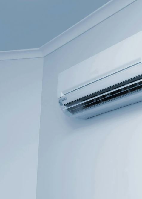 Wall-mounted split air conditioning unit installed in a room corner.