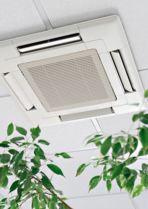 Ceiling-mounted cassette air conditioning unit with plants visible in the foreground.